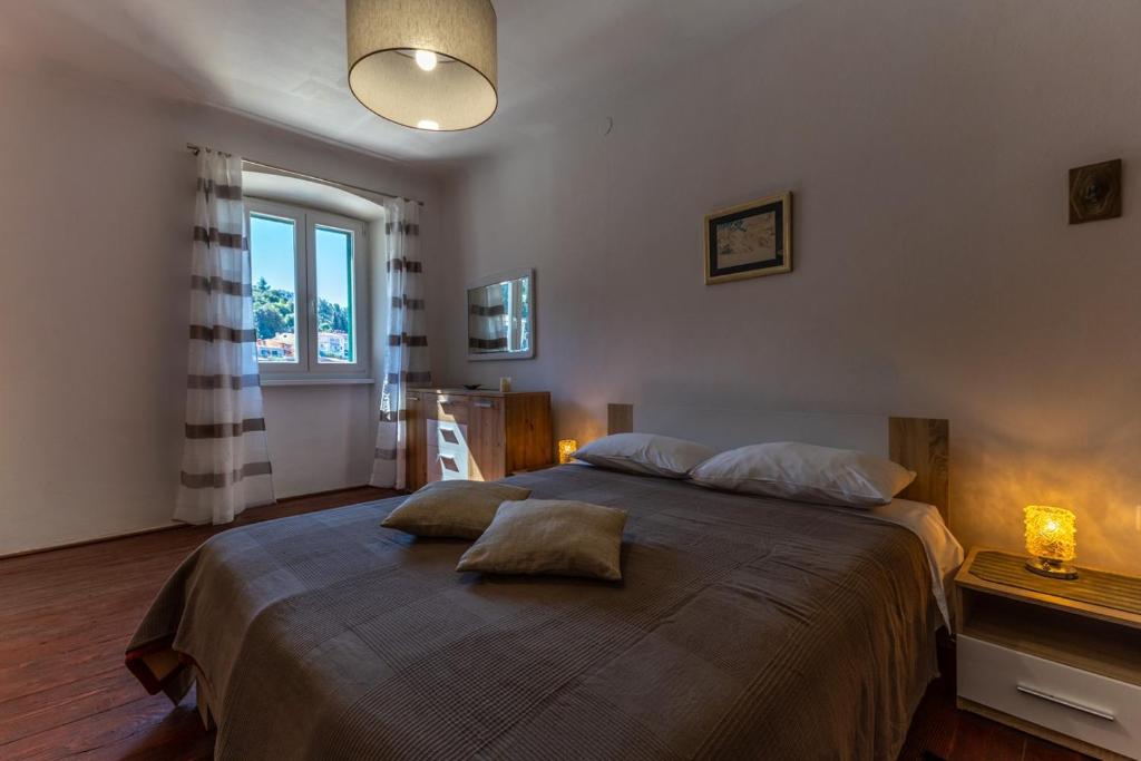 Double bedroom with bedside lights and a window overlooking Rabac