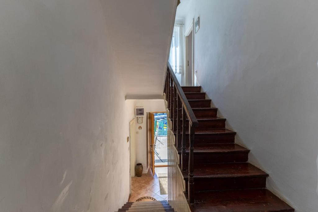 The house entrance and hallway with worn wooden stairs and a wooden banister