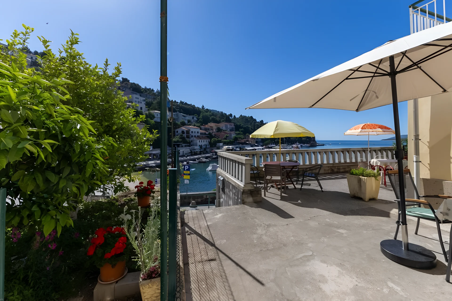 Apartment terrace with shaded outdoor seating overlooking Rabac harbour and the Adriatic Sea